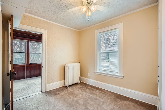 carpeted spare room with crown molding, a textured ceiling, radiator, and a ceiling fan