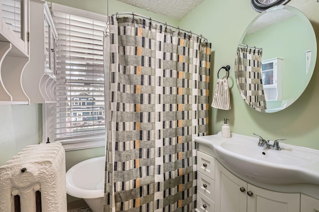 bathroom with vanity, a textured ceiling, and radiator