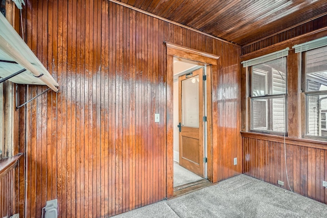 interior space with wooden ceiling, wooden walls, and carpet floors