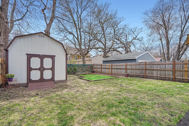 view of yard with a storage shed, an outbuilding, and a fenced backyard
