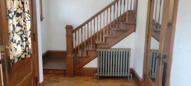 3229 Chicago Ave, Minneapolis, MN 55407 - staircase with radiator heating unit and wood finished floors