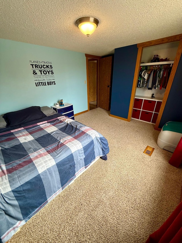 bedroom with a closet, a textured ceiling, and carpet floors