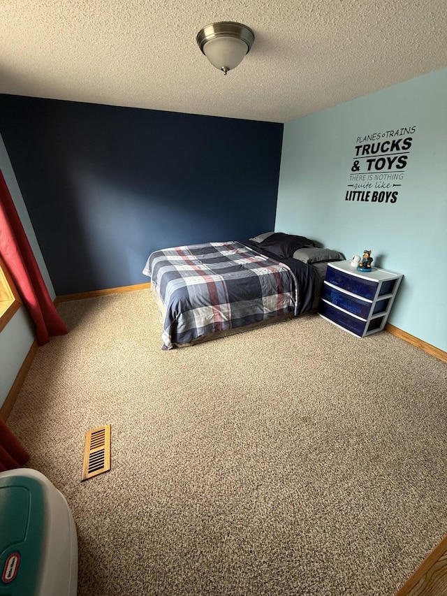 carpeted bedroom featuring a textured ceiling and baseboards