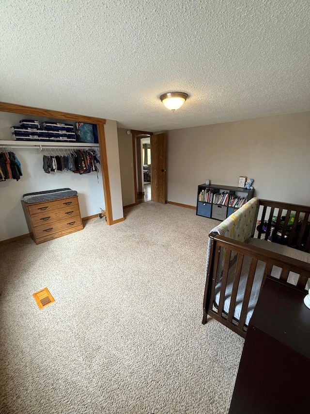 bedroom featuring carpet floors, a textured ceiling, and baseboards