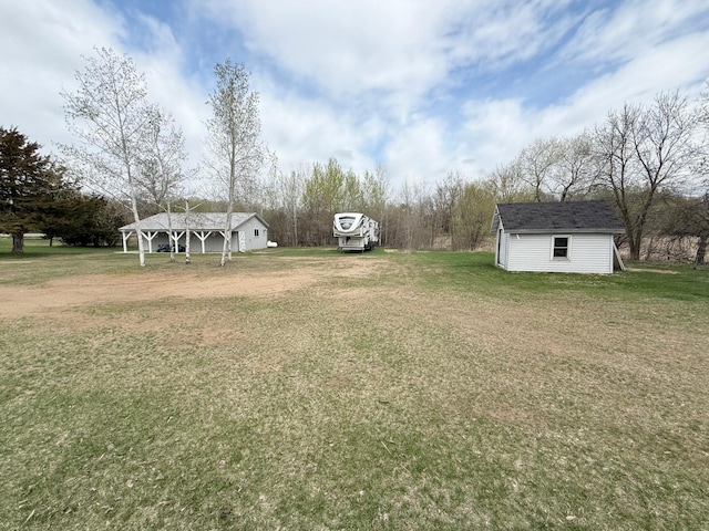 view of grassy yard with an outdoor structure