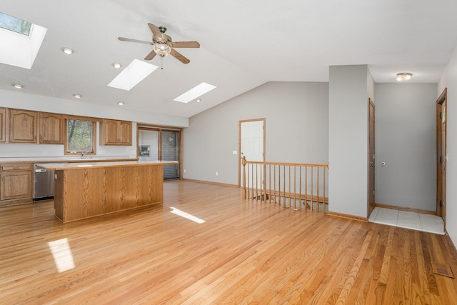 4416 Louisiana Ave N, Crystal, MN 55428 - kitchen featuring a skylight, stainless steel dishwasher, a kitchen island, light countertops, and light wood-style floors