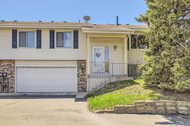 view of front of home featuring driveway, brick siding, and an attached garage