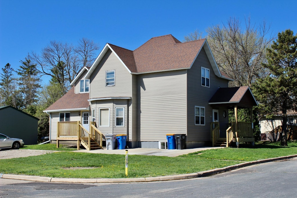 view of front of house with a front lawn and roof with shingles