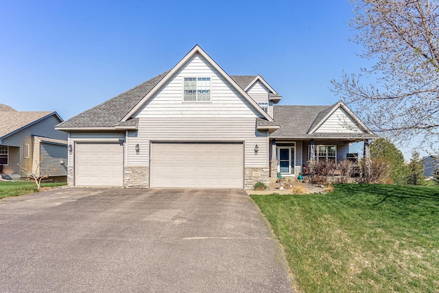 1103 Park Ln SE, New Prague, MN 56071 - view of front of property with asphalt driveway, a front yard, roof with shingles, stone siding, and a porch