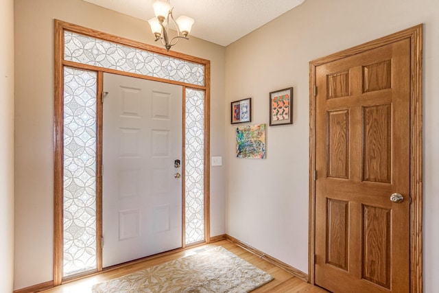 1103 Park Ln SE, New Prague, MN 56071 - entryway with a chandelier, light wood-style flooring, and baseboards