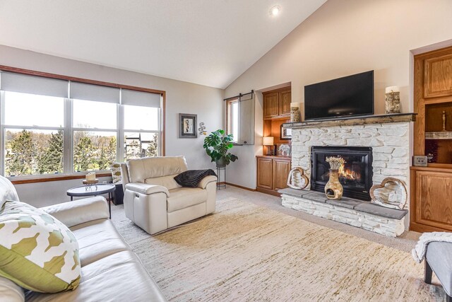 1103 Park Ln SE, New Prague, MN 56071 - living area with a stone fireplace, light carpet, baseboards, and high vaulted ceiling