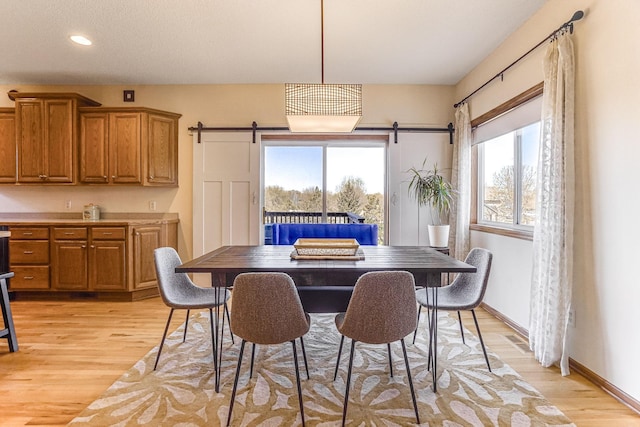1103 Park Ln SE, New Prague, MN 56071 - dining area with a barn door, light wood-style floors, healthy amount of natural light, recessed lighting, and baseboards