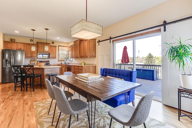 1103 Park Ln SE, New Prague, MN 56071 - dining space with a barn door, light wood-type flooring, and recessed lighting