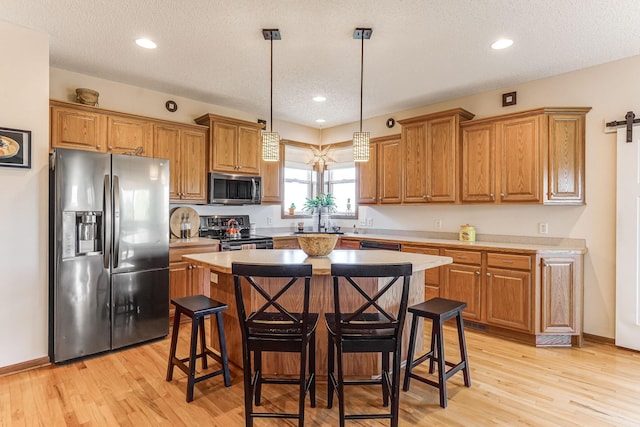 1103 Park Ln SE, New Prague, MN 56071 - kitchen with appliances with stainless steel finishes, a kitchen island, brown cabinetry, a breakfast bar area, and recessed lighting