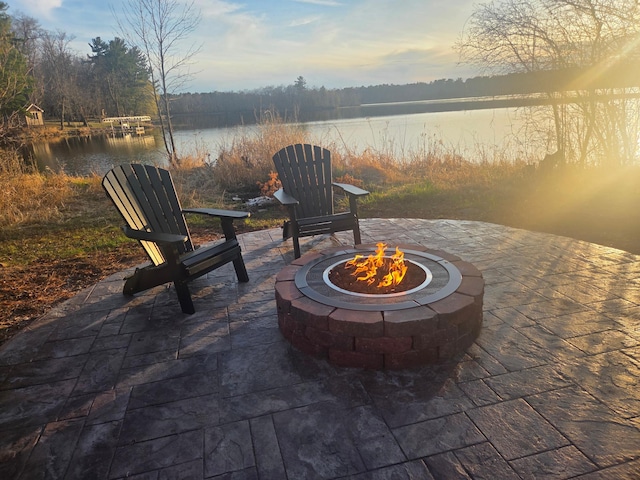 view of patio / terrace with an outdoor fire pit and a water view