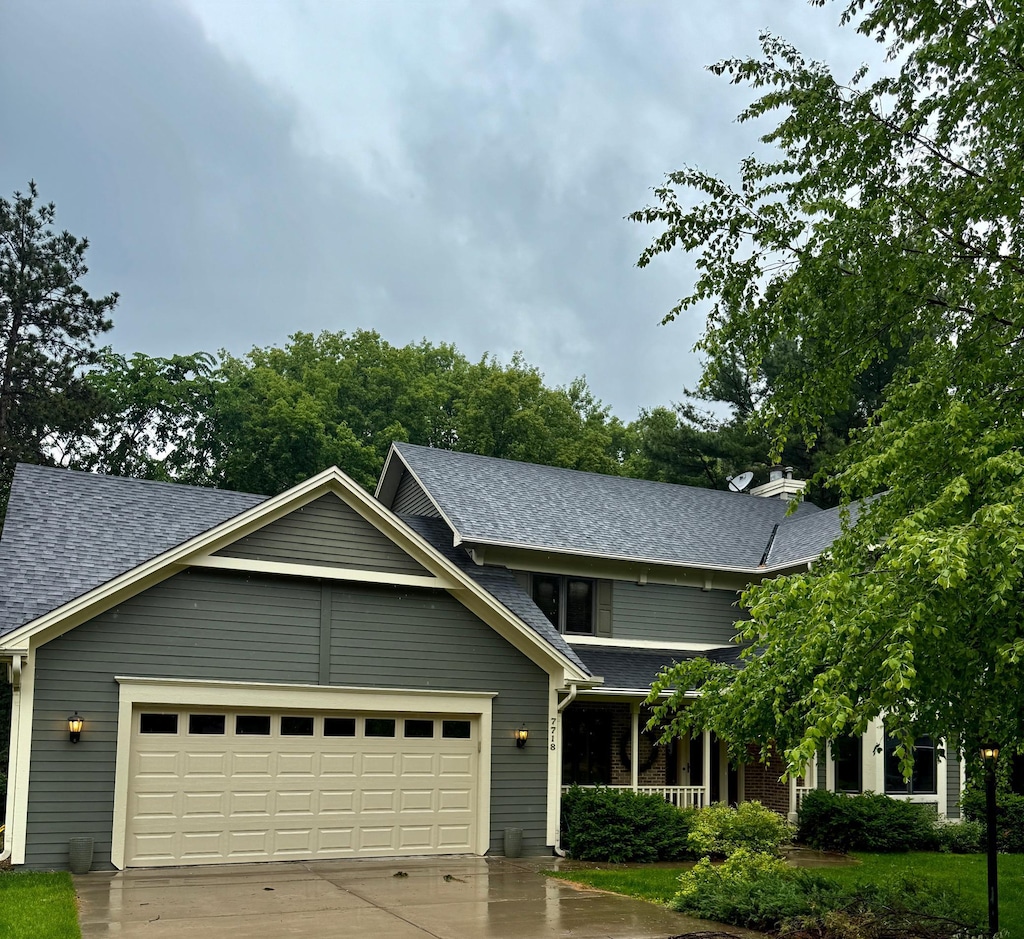 7718 74th St S, Cottage Grove, MN 55016 - view of front of house with a shingled roof, concrete driveway, a garage, and a porch