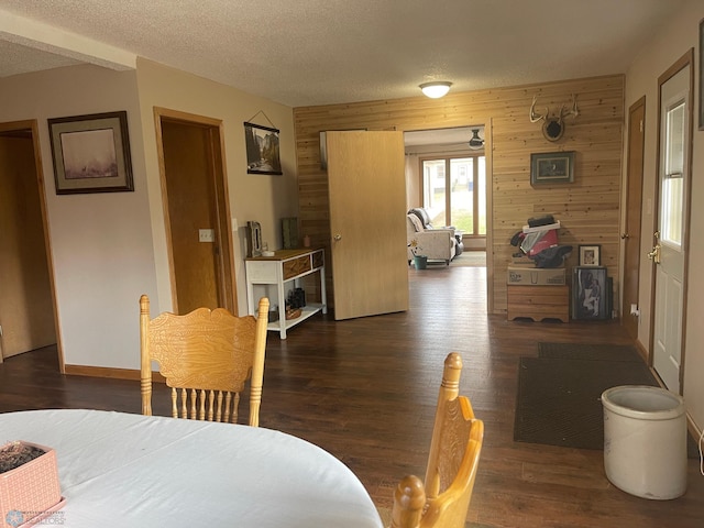 101 Oak St, Lisbon, ND 58054 - dining space with wooden walls, wood finished floors, baseboards, and a textured ceiling