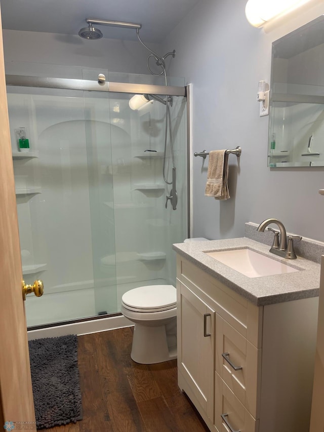 101 Oak St, Lisbon, ND 58054 - bathroom with wood finished floors, a stall shower, vanity, and toilet