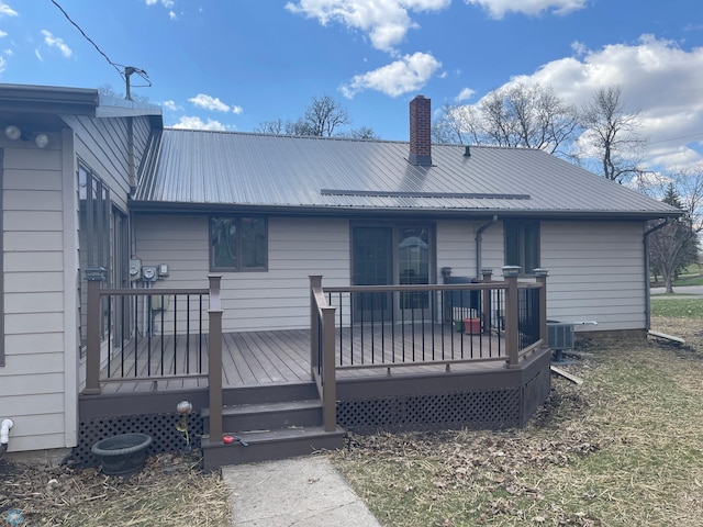 101 Oak St, Lisbon, ND 58054 - rear view of property with metal roof, a wooden deck, and a chimney