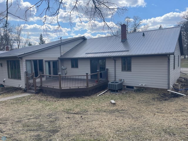 101 Oak St, Lisbon, ND 58054 - rear view of property featuring central air condition unit, a chimney, a deck, metal roof, and a lawn