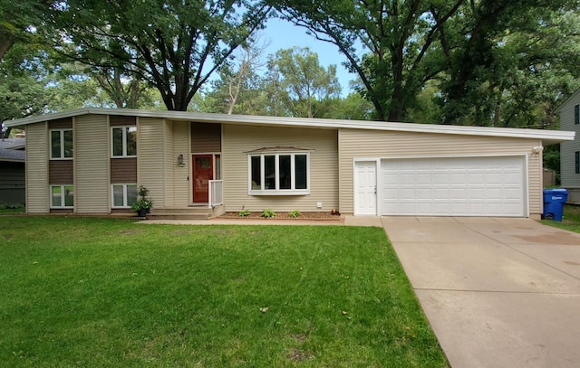 tri-level home with driveway, an attached garage, and a front yard