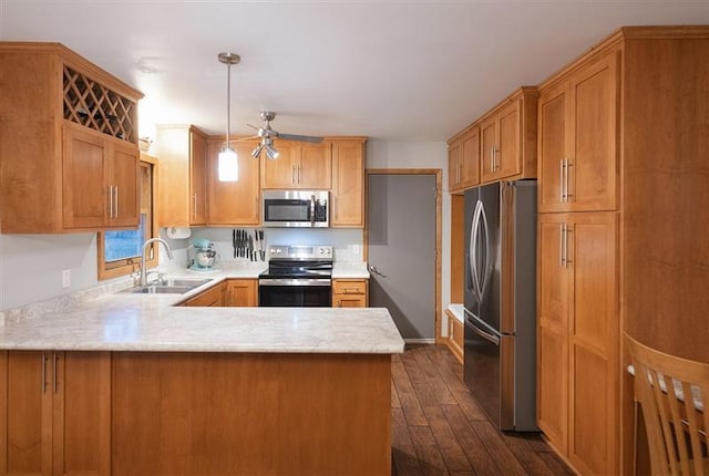 kitchen with a sink, a peninsula, stainless steel appliances, light countertops, and dark wood-style floors