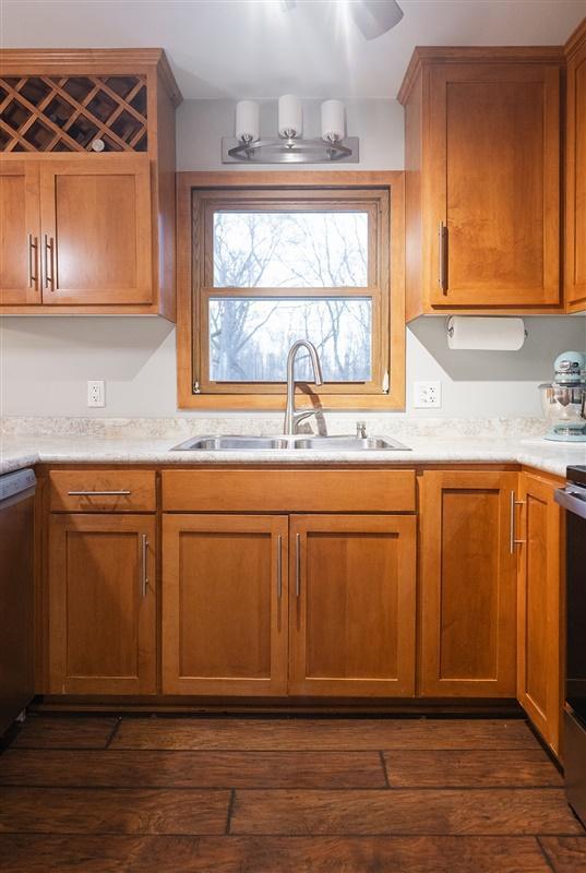 kitchen with dark wood-style flooring, light countertops, and a sink