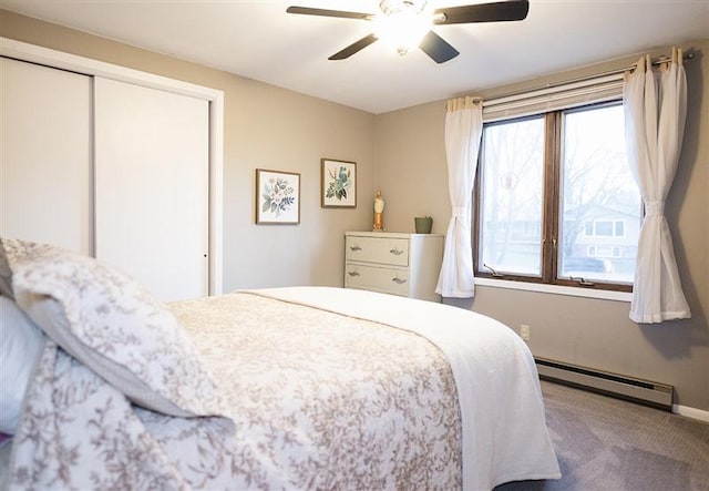carpeted bedroom featuring a closet, a ceiling fan, baseboards, and a baseboard heating unit