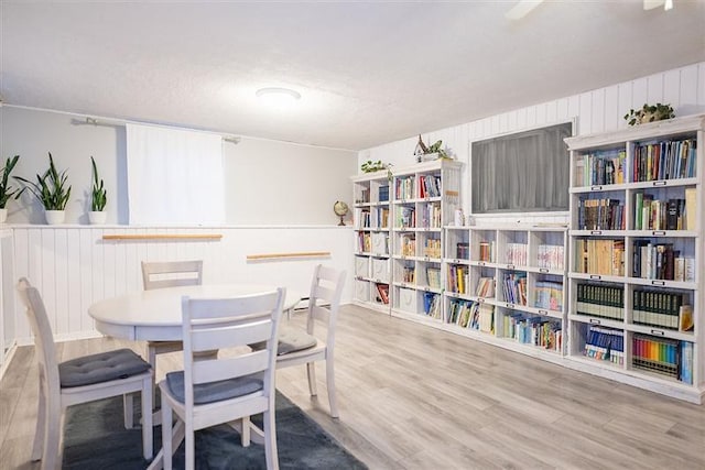 dining area with wood walls and wood finished floors