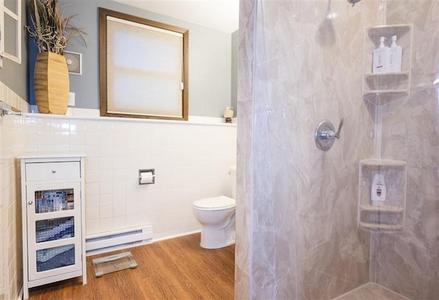 bathroom featuring tile walls, wood finished floors, a baseboard heating unit, and a walk in shower