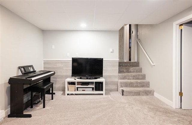 living area with a drop ceiling, stairway, baseboards, and carpet floors
