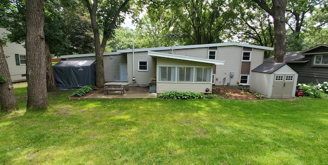 back of house featuring a yard, a patio area, an outdoor structure, and a storage shed