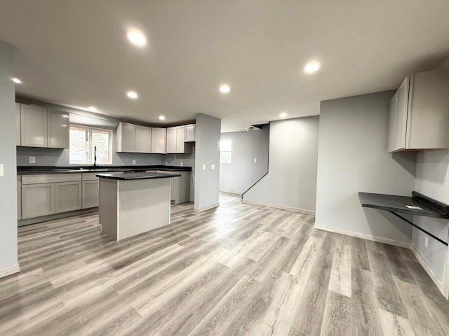 kitchen featuring baseboards, dark countertops, light wood-style flooring, and recessed lighting