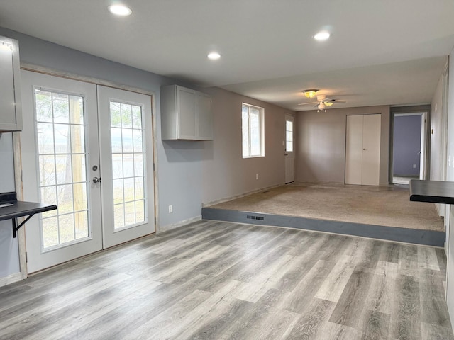 unfurnished living room with a ceiling fan, french doors, recessed lighting, light wood finished floors, and visible vents