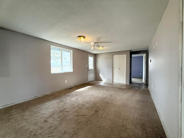 unfurnished bedroom featuring carpet flooring, a textured ceiling, visible vents, and baseboards