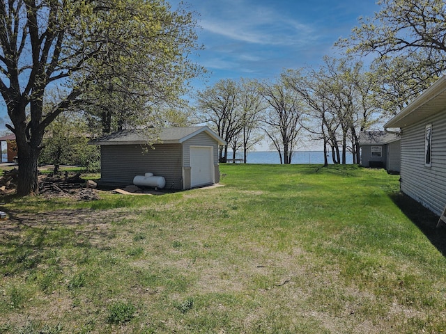 44948 Plentywood Rd, Perham, MN 56573 - view of green lawn with a water view, a detached garage, and an outdoor structure