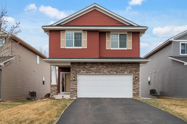 view of front facade with stone siding, a garage, asphalt driveway, a front lawn, and cooling unit