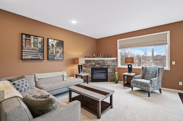 living area with light colored carpet, baseboards, and a stone fireplace