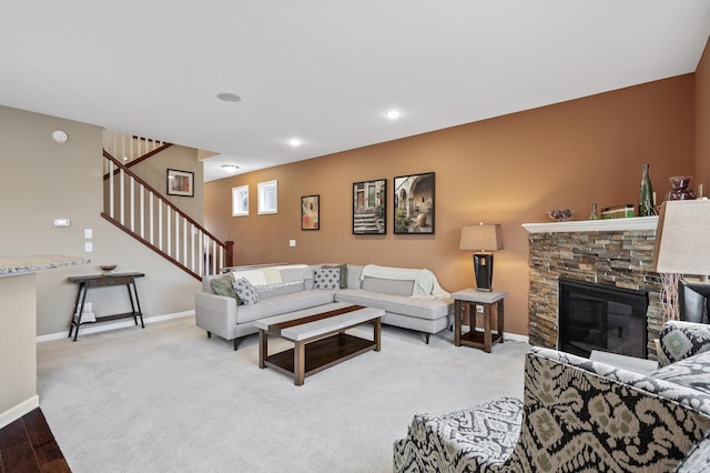 living room featuring stairway, baseboards, a fireplace, light colored carpet, and recessed lighting