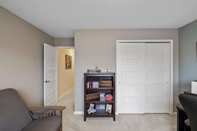 living area with light colored carpet and baseboards