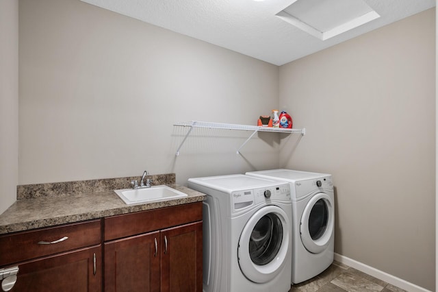 laundry area with a sink, washing machine and dryer, baseboards, and attic access