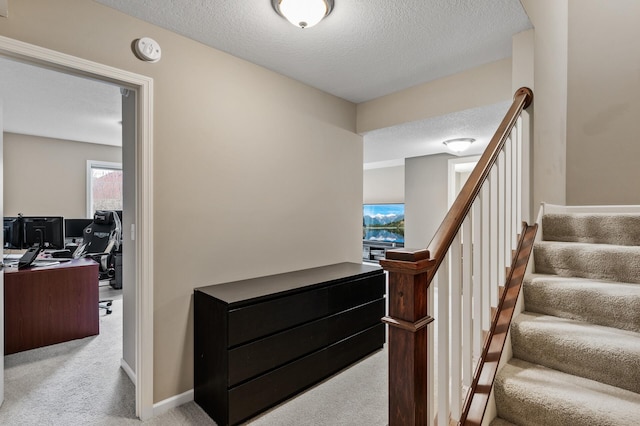 stairs featuring a textured ceiling and carpet