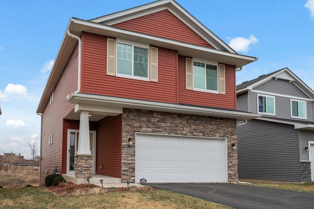 craftsman-style home with stone siding, an attached garage, and asphalt driveway