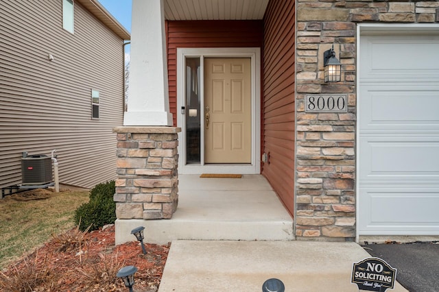 entrance to property with stone siding and central AC