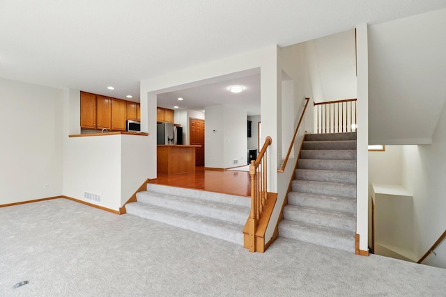 stairs with baseboards, recessed lighting, carpet flooring, and visible vents