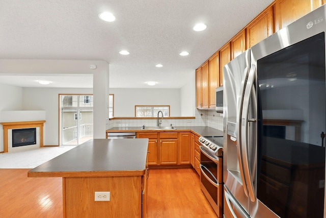 kitchen featuring recessed lighting, light wood-style floors, appliances with stainless steel finishes, and a sink