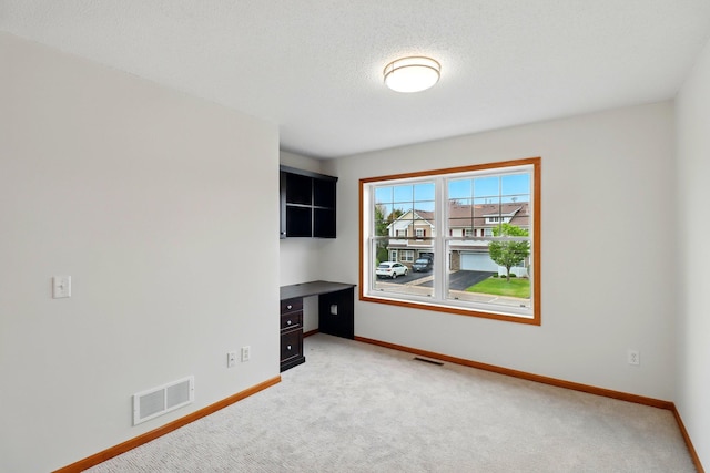 empty room with light colored carpet, baseboards, and visible vents