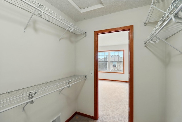 walk in closet with visible vents and dark carpet