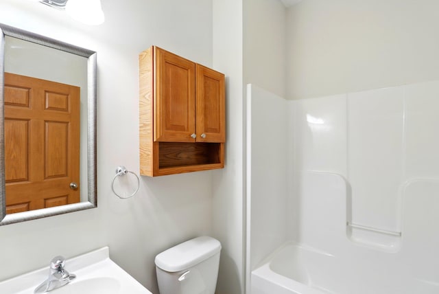 bathroom with toilet, a shower, and a sink