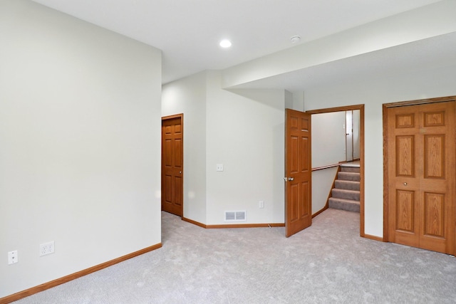 carpeted spare room with stairway, baseboards, visible vents, and recessed lighting